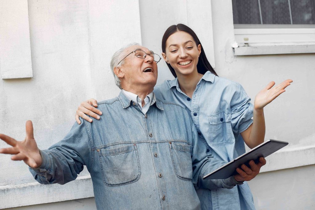 young woman teaching her grandfather how use tablet
